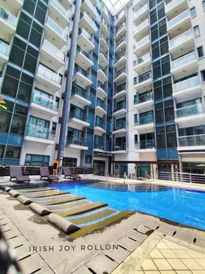 a swimming pool in front of a tall building at Condotel Near Naia Terminal 3 in Manila