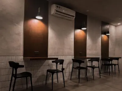 a bar with black stools in a room at Yamato Hostel in Manila