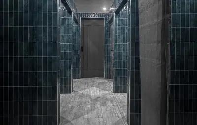 a hallway with glass tile walls and a door at Yamato Hostel in Manila