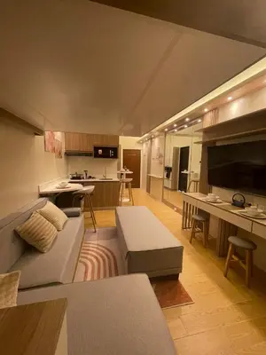 a living room with a couch and a kitchen at Nordic Rsquare Manila - with Pool Access in Manila