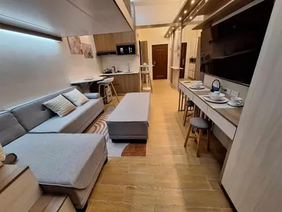 a living room with a couch and a table at Nordic Rsquare Manila - with Pool Access in Manila