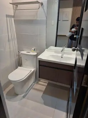 a bathroom with a toilet and a sink and a mirror at Nordic Rsquare Manila - with Pool Access in Manila