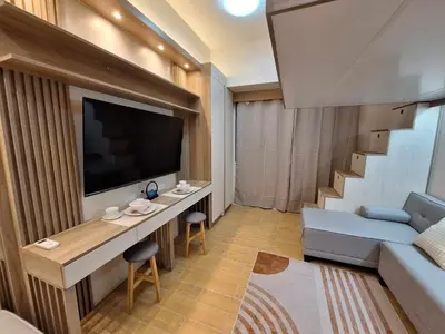 a living room with a couch and a flat screen tv at Nordic Rsquare Manila - with Pool Access in Manila