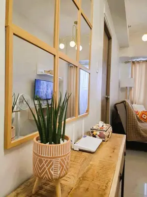 a potted plant on a wooden table in a room at Comfy Condo Near NAIA Airport in Manila