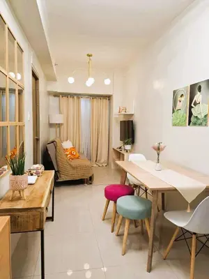 a living room with a table and some chairs at Comfy Condo Near NAIA Airport in Manila