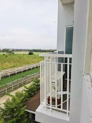 a balcony with a white chair on a house at Comfy Condo Near NAIA Airport in Manila