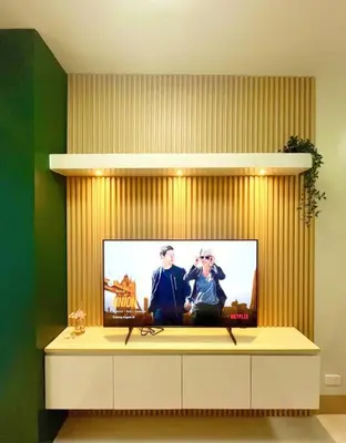 a flat screen tv sitting on top of a cabinet at Cozy and aesthetic unit near MOA Airport and IKEA in Manila