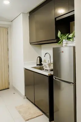 a kitchen with a stainless steel refrigerator and a sink at Luxe Suite at BCCT - BGC's Prime Studio - Gym, Infinity Pool with breathtaking skyline view in Manila