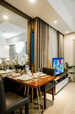 a dining room with a table and a television at Luxe Suite at BCCT - BGC's Prime Studio - Gym, Infinity Pool with breathtaking skyline view in Manila