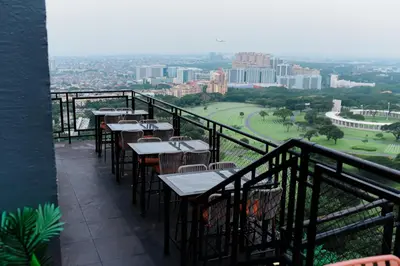 a balcony with tables and chairs and a view of the city at Luxe Suite at BCCT - BGC's Prime Studio - Gym, Infinity Pool with breathtaking skyline view in Manila