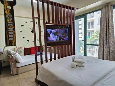 a bedroom with a bed and a tv in a room at Two Palmtree Villas cluster3 rooms across NAIA terminal 3 in Manila