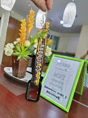 a person holding a key chain with a sign on a table at Two Palmtree Villas cluster3 rooms across NAIA terminal 3 in Manila