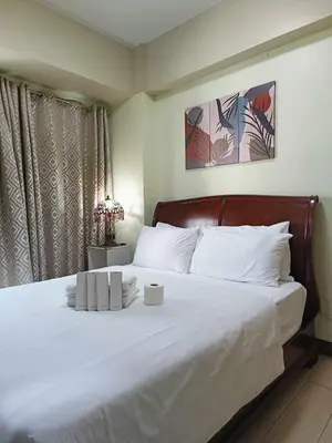 a bedroom with a large white bed with white pillows at Two Palmtree Villas cluster3 rooms across NAIA terminal 3 in Manila