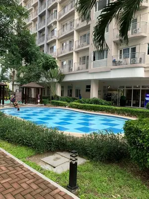 a swimming pool in front of a large building at south residences in Manila