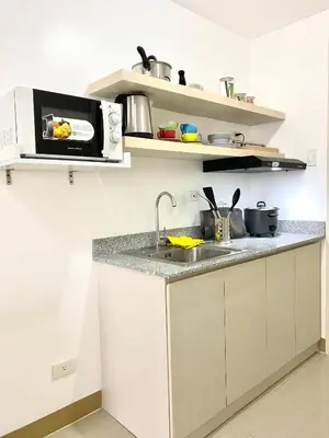 a kitchen with a sink and a microwave at south residences in Manila