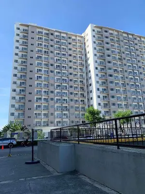 a large apartment building in front of a parking lot at south residences in Manila