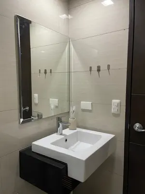 a bathroom with a white sink and a mirror at Cozy space in Viceroy Residences McKinley Hill Taguig in Manila