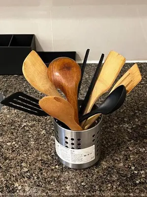 a metal container filled with wooden utensils on a counter at Cozy space in Viceroy Residences McKinley Hill Taguig in Manila