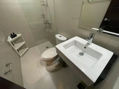 a white bathroom with a sink and a toilet at Cozy space in Viceroy Residences McKinley Hill Taguig in Manila