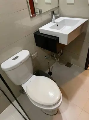 a bathroom with a white toilet and a sink at Cozy space in Viceroy Residences McKinley Hill Taguig in Manila
