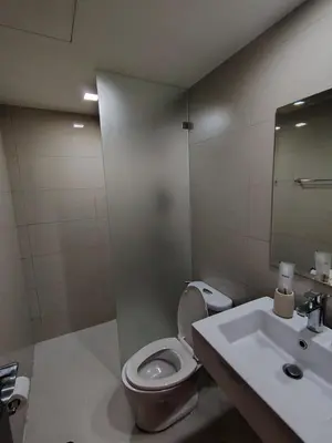 a bathroom with a toilet and a sink at Cozy space in Viceroy Residences McKinley Hill Taguig in Manila
