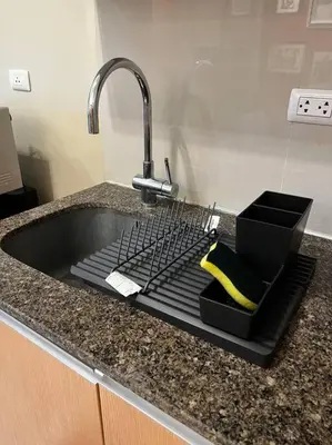 a sink in a kitchen with a faucet at Cozy space in Viceroy Residences McKinley Hill Taguig in Manila
