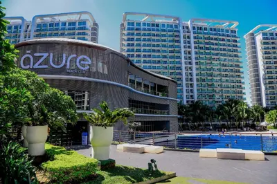 a building with a swimming pool in front of tall buildings at Azure Urban Resort Staycation 1 Bedroom Beach View, 18th floor in Manila