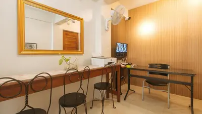 a room with a bar with stools and a mirror at RedDoorz at Delorian Residences in Manila