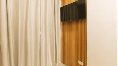 a curtain with a television on top of it at RedDoorz at Delorian Residences in Manila