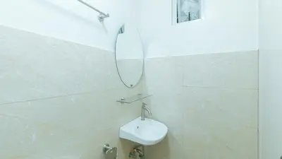 a white bathroom with a mirror and a sink at RedDoorz at Delorian Residences in Manila