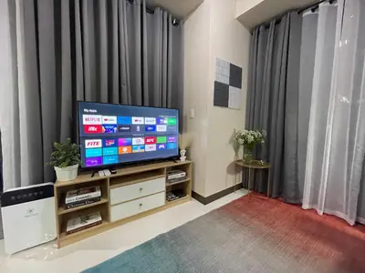 a living room with a flat screen tv on a stand at Executive luxury 2BR Condo Unit in McKinley Hill BGC Taguig in Manila