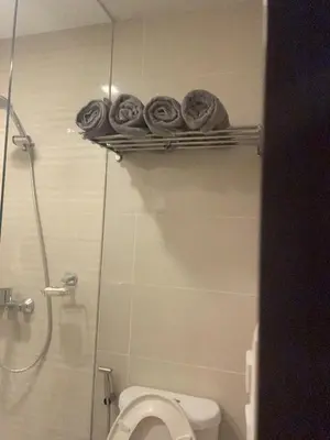 a bathroom with a toilet and towels on a shelf at Executive luxury 2BR Condo Unit in McKinley Hill BGC Taguig in Manila