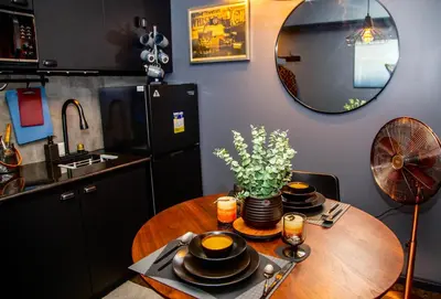 a kitchen with a wooden table with plates and a mirror at Azure Urban Resort Staycation 1Bedroom with PS4, 3rd floor in Manila