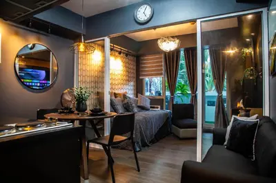 a living room with a couch and a table and a clock at Azure Urban Resort Staycation 1Bedroom with PS4, 3rd floor in Manila