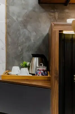 a wooden cabinet with a tea kettle and cups at 1BR Makati, Lush Residences M004 in Manila
