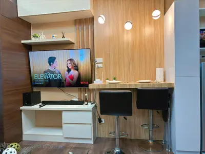 a room with a tv on a wall with a desk at 1BR Makati, Air Residences M005 in Manila