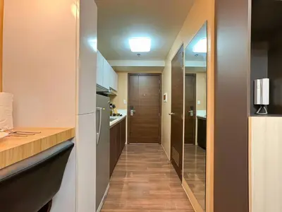 a hallway leading to a kitchen with a sliding door at 1BR Makati, Air Residences M005 in Manila