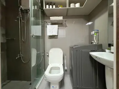 a bathroom with a shower and a toilet and a sink at 1BR Makati, Air Residences M005 in Manila