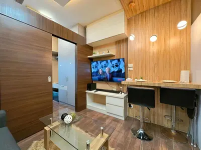 a living room with a tv and a glass table at 1BR Makati, Air Residences M005 in Manila