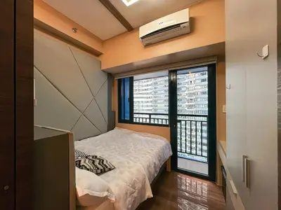 a bedroom with a bed and a large window at 1BR Makati, Air Residences M005 in Manila