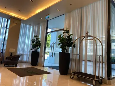 a lobby with two potted plants in a building at Cozy Blossom near NAIA in Manila