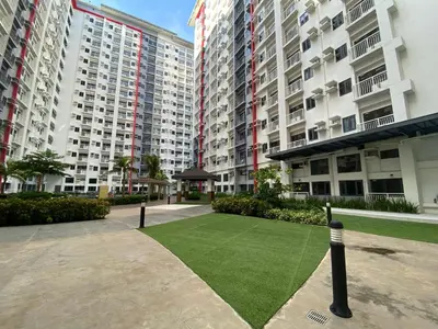 a artificial lawn in front of two tall buildings at Cozy Blossom near NAIA in Manila