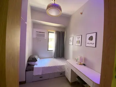 a small bedroom with a bed and a window at Cozy Blossom near NAIA in Manila
