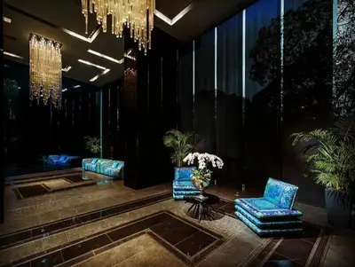 a lobby with two chairs and a table and a chandelier at Spacious 1BR Milano by Versace in Makati in Manila
