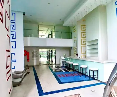 a lobby with a swimming pool and some chairs at Spacious 1BR Milano by Versace in Makati in Manila