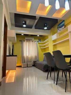 a bedroom with a bed and a table and chairs at 1-Bedroom condo with pool across NAIA Terminal 3 in Manila