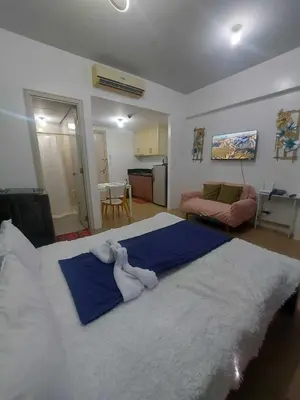 a bedroom with a large bed with two stuffed animals on it at cozy Avah condotel newport in Manila