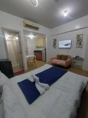 a bedroom with a large bed with towels on it at cozy Avah condotel newport in Manila
