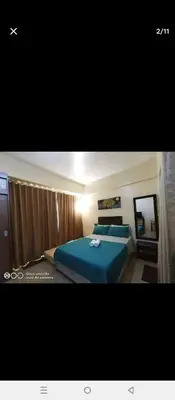 a bedroom with a blue bed and a mirror at cozy Avah condotel newport in Manila