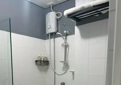 a shower in a bathroom with a shower head at Cobblestone City Stays - SM Mezza 1 Residences in Manila